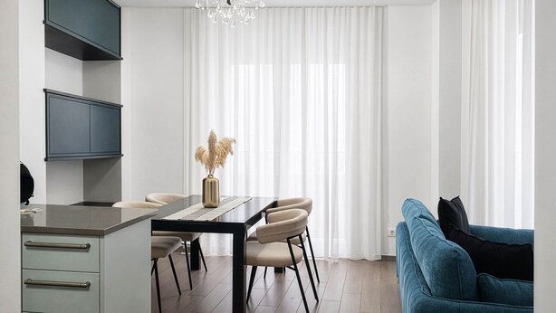 A modern kitchen with a dining table and chairs, a sofa, and a chandelier. - Maison Michela Sorrento (Sorrento)