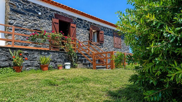 A stone building with a wooden staircase and potted plants.