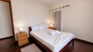 A hotel room with a bed, bedside tables, and a window with curtains. - Casa da Achada de Cima (Calheta)