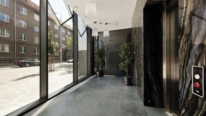 A modern elevator with a marble wall and a control panel. - Luxury Apartment in Prime Area (Tallinn)