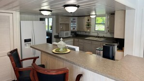 Una cocina moderna con una isla central, sillas de madera e iluminación colgante.