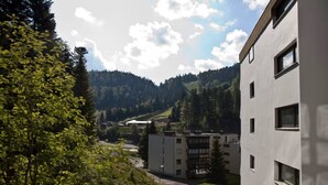 A modern building with multiple windows and a view of a mountainous landscape.