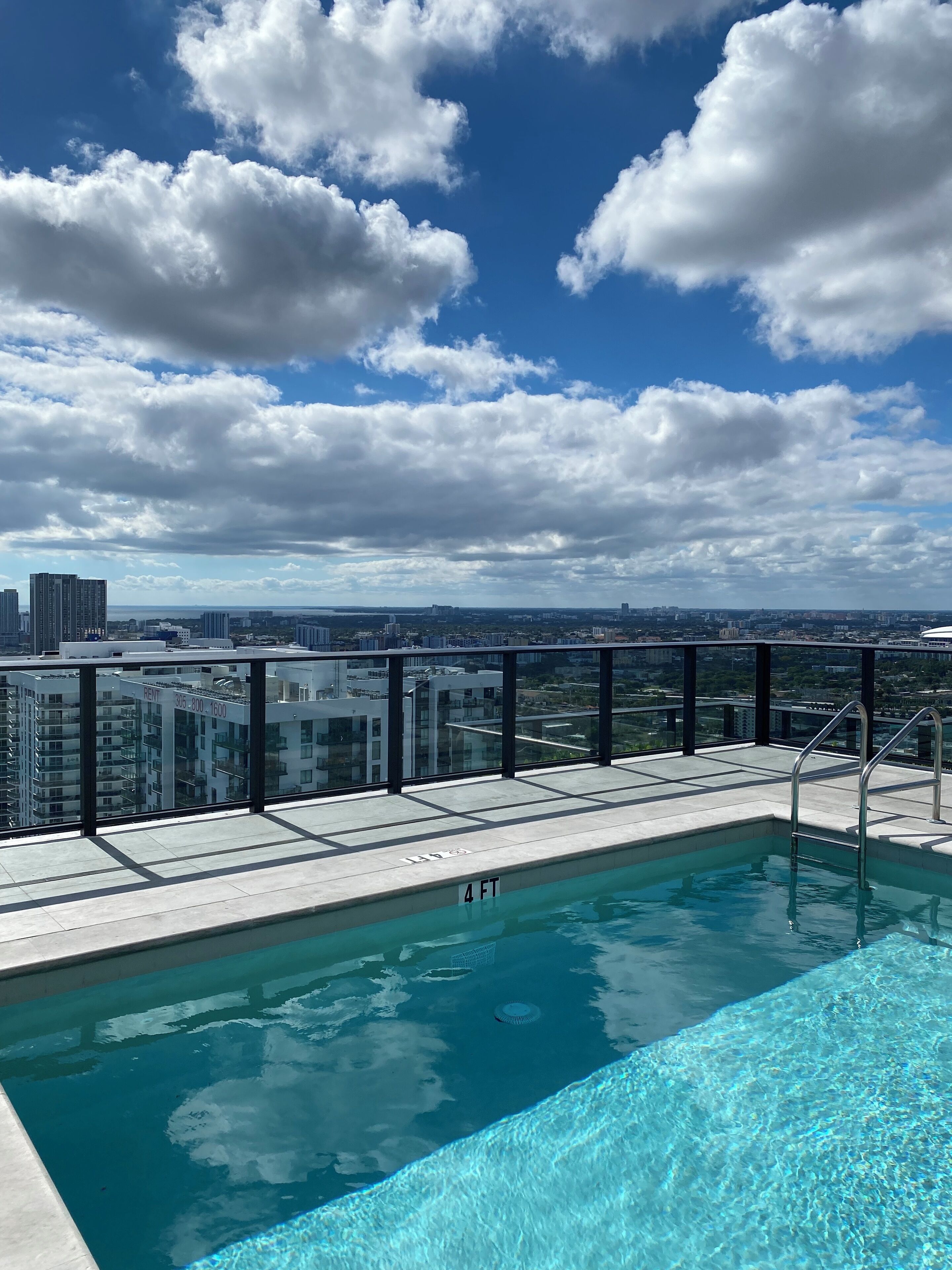 Une piscine sur le toit offrant une vue dégagée sur le paysage urbain et les bâtiments en arrière-plan.