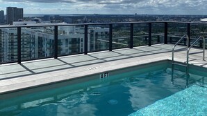 A rooftop pool with a clear view of the cityscape and buildings in the background.