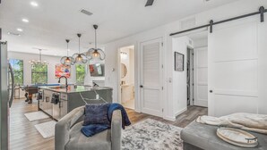 A modern kitchen with a central island, pendant lighting, and a view of the outdoors. - Modern Ybor City Townhouse with Rooftop Views (Tampa)