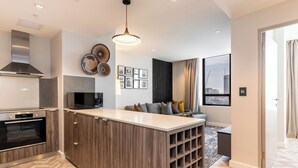 A modern kitchen with a central island, built-in oven, and stainless steel range hood.