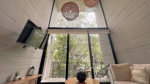 Ein modernes Interieur mit einem großen Fenster, einem Flachbildfernseher und einem Holztisch.