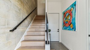 Eine Treppe mit Holzboden und Metallgeländer, die zu einer weißen Tür führt.