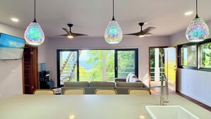 Un comedor moderno con una mesa grande, sillas y un ventilador de techo.
