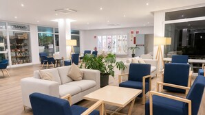 Un hall d’hôtel moderne avec un espace salon, une table basse et une plante en pot.
