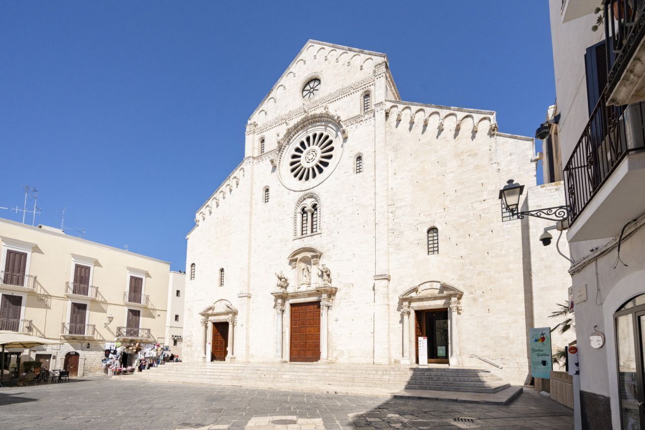 A historic building with a large central clock, arched windows, and a symmetrical facade.