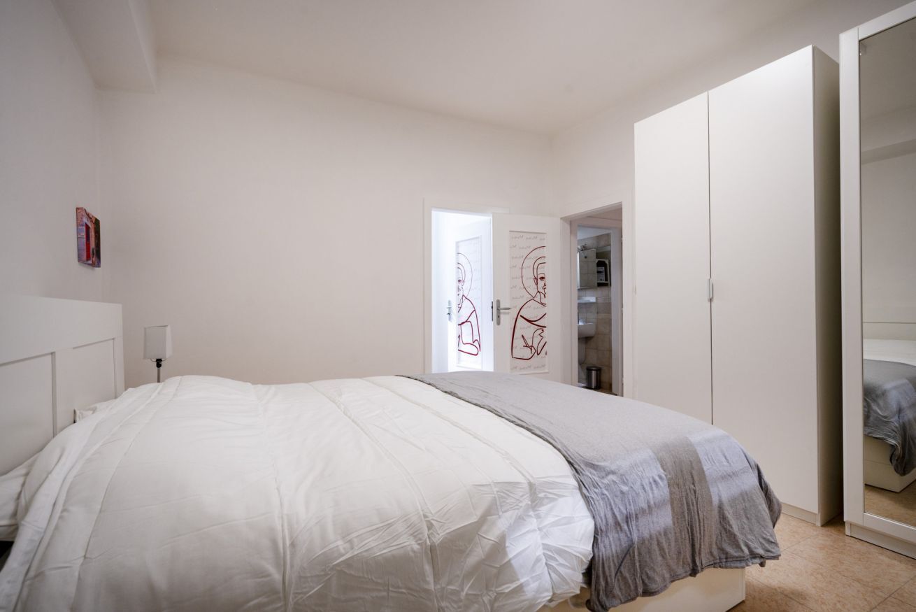 Un dormitorio con cama, armario y puerta con un póster.