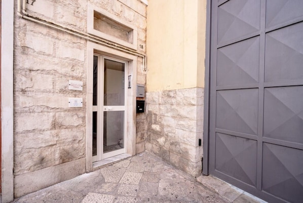 Un edificio de piedra con una puerta, un buzón y una puerta de garaje.