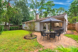 A patio with a table and chairs, a small garden, and a house with a chimney. - 1 story, family friendly 3bdr in The Woodlands! ! (Spring)