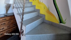 A staircase with a handrail, a wall mural with palm trees and birds, and a Galaxy A54 5G sign. - 15 minutes from Turin. Matilda House (Piemonte)
