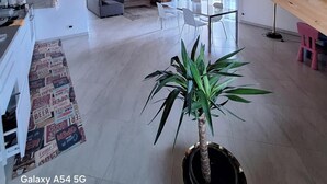 A spacious living area with a high ceiling and wooden beams, a dining table, chairs, a sofa, and a potted plant. - 15 minutes from Turin. Matilda House (Piemonte)