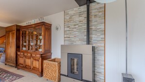 Une pièce avec une armoire en bois, une cheminée et un mur en pierre.