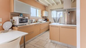 Une cuisine équipée d’un four à micro-ondes, d’une cuisinière, d’un évier et de placards.