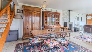 Un coin repas avec une table et des chaises en bois, un tapis à motifs et un escalier.
