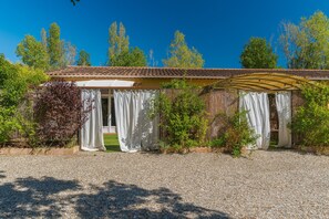 A building with a tiled roof, a covered porch, and a gravel driveway. - Domaine Plan des Devens – Peaceful 4* Retreat with Terrace and Heated Pool (Roussillon)