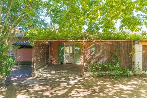 A covered outdoor area with a wooden structure, a door, and a fenced area. - Domaine Plan des Devens – Peaceful 4-Star Retreat with Heated Pool (Roussillon)