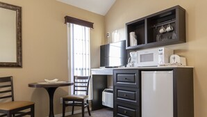 A compact kitchen with a refrigerator, microwave, and a small dining area with a table and chairs. - Charming Studio w/ Pool Access in Branson (Branson)