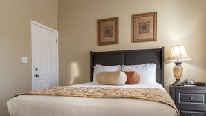 A hotel room with a large bed, a nightstand with a lamp, and two framed pictures on the wall. - Charming Studio w/ Pool Access in Branson (Branson)