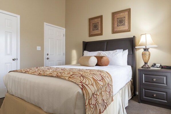 A hotel room with a bed, a nightstand, and two framed pictures on the wall. - Charming Studio w/ Pool Access in Branson (Branson)