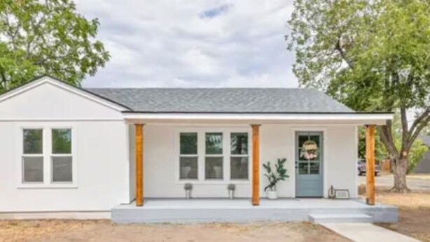 Une maison de plain-pied avec un porche à l’avant, une porte et des fenêtres.