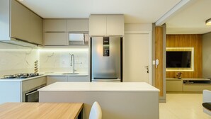 Uma cozinha moderna com ilha central, eletrodomésticos embutidos e design elegante.