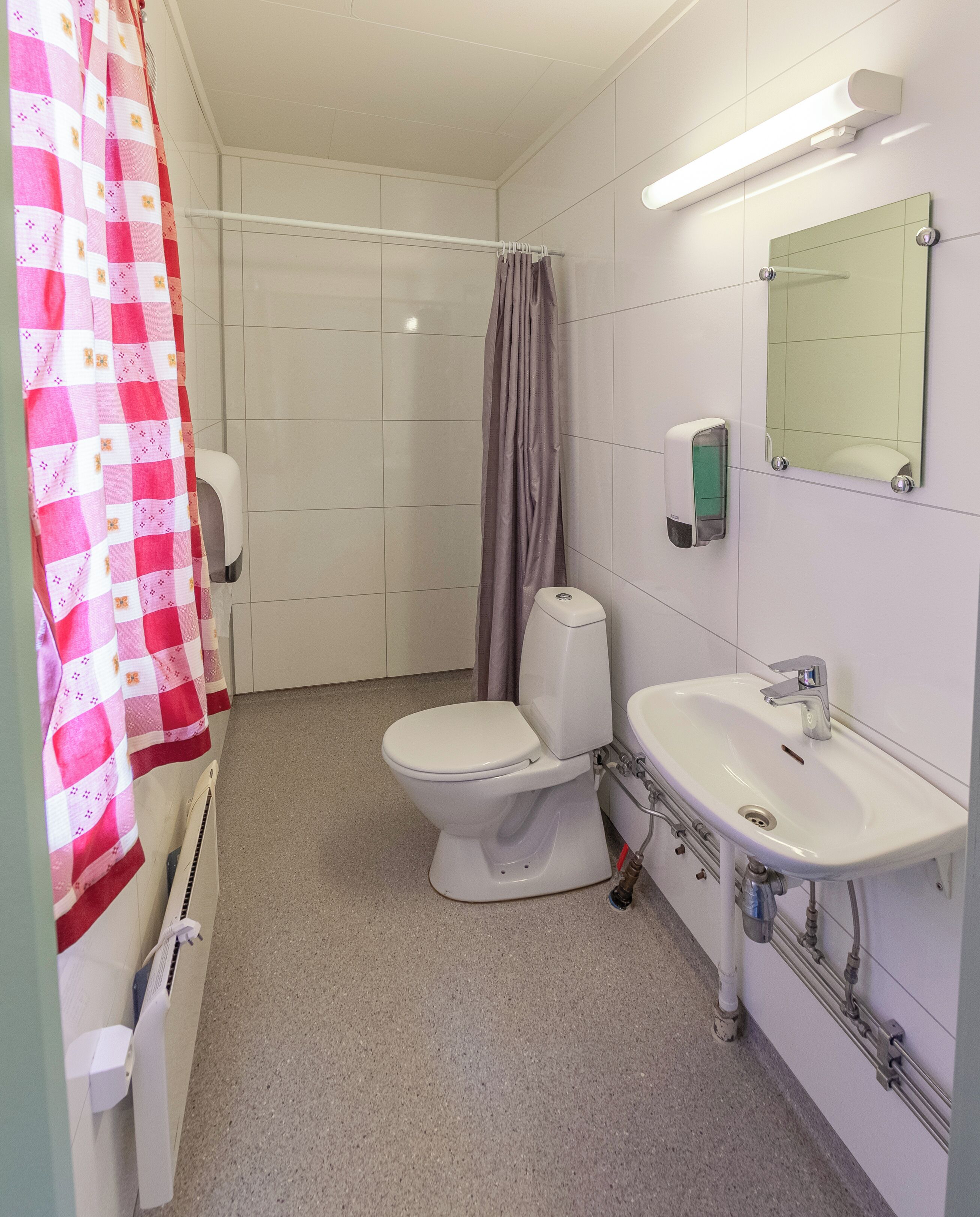 Un baño con inodoro, lavabo y cortina de ducha.