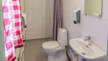 Un baño con inodoro, lavabo y cortina de ducha.