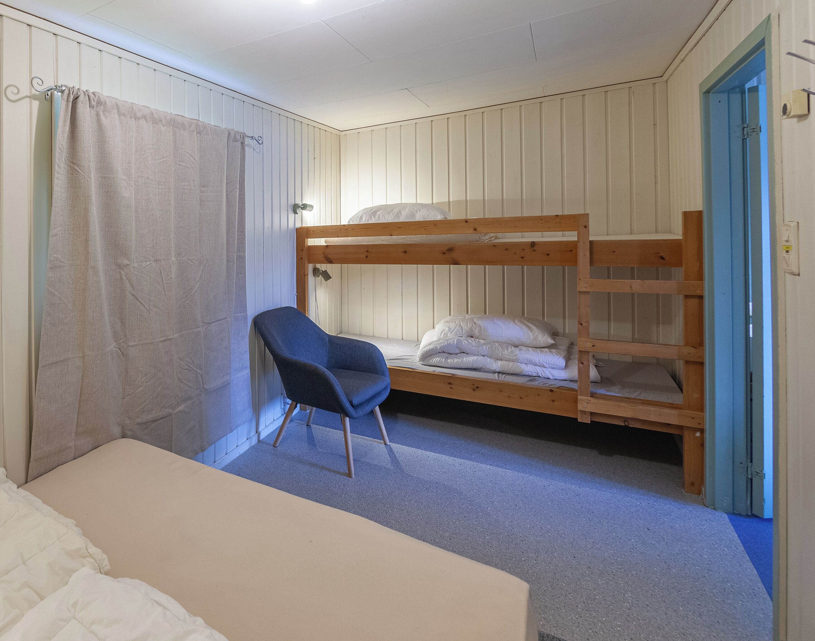 Una habitación con una cama individual, una silla y una cama.