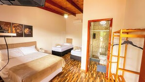 A bedroom with a bed, bedside tables, a shower area, and a wooden floor. - Clube Relax & Lazer (Foz do Iguaçu)