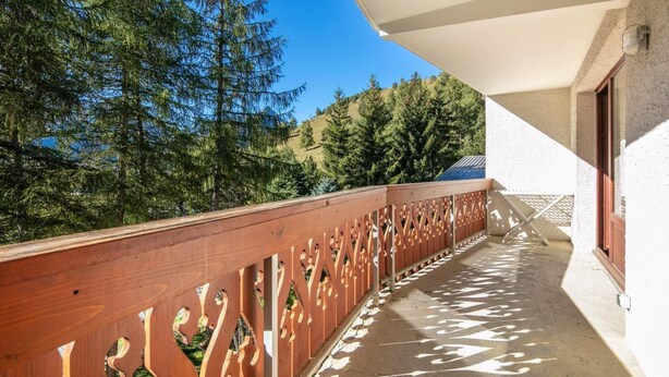 A balcony with a wooden railing and a view of trees and hills. - 50m from ski slopes, ski locker, 25-30m², Les 2 Alpes (Les Deux Alpes)