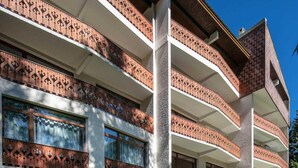 A multi-story building with balconies featuring intricate wrought iron railings. - 50m from ski slopes, ski locker, 25-30m², Les 2 Alpes (Les Deux Alpes)