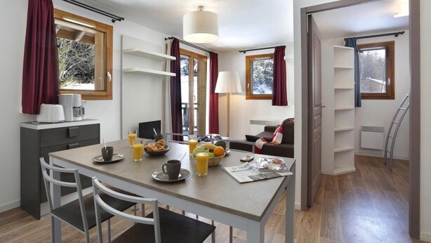 A modern, well-lit room with a dining table set for breakfast, a sofa, and a ladder in the corner. - 200m from resort center, terrace, balcony, tv, 35-50m², Les 2 Alpes (Les Deux Alpes)
