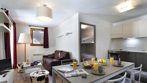 A compact living space with a sofa, a dining table with breakfast items, a kitchenette, and a small TV. - 200m from resort center, terrace, balcony, tv, 35-50m², Les 2 Alpes (Les Deux Alpes)