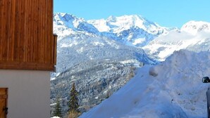A wooden cabin with a balcony overlooking a snowy mountain range. - 200m from resort center, swimming pool, sauna, tv, ski locker, 23m², Valfréjus (Valfréjus)