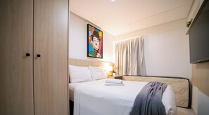 A hotel room with a bed, a nightstand, a painting, and a TV. - Chaves do Atlântico (Cabedelo)