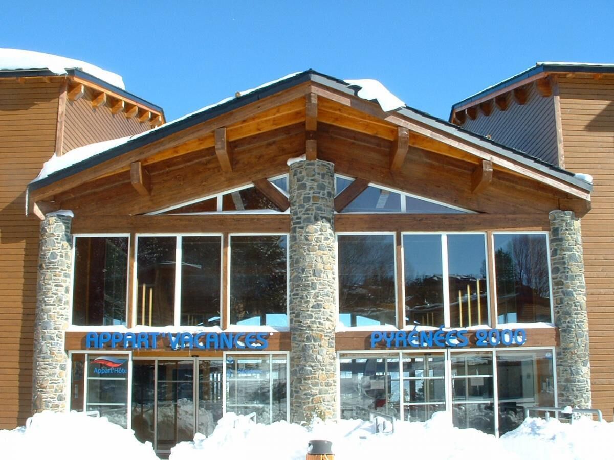 Un hotel con fachada de piedra y amplias ventanas.
