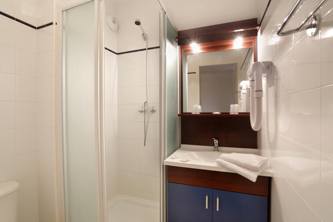 Une salle de bain moderne avec une douche à parois de verre, un meuble-lavabo avec un miroir et un porte-serviettes.