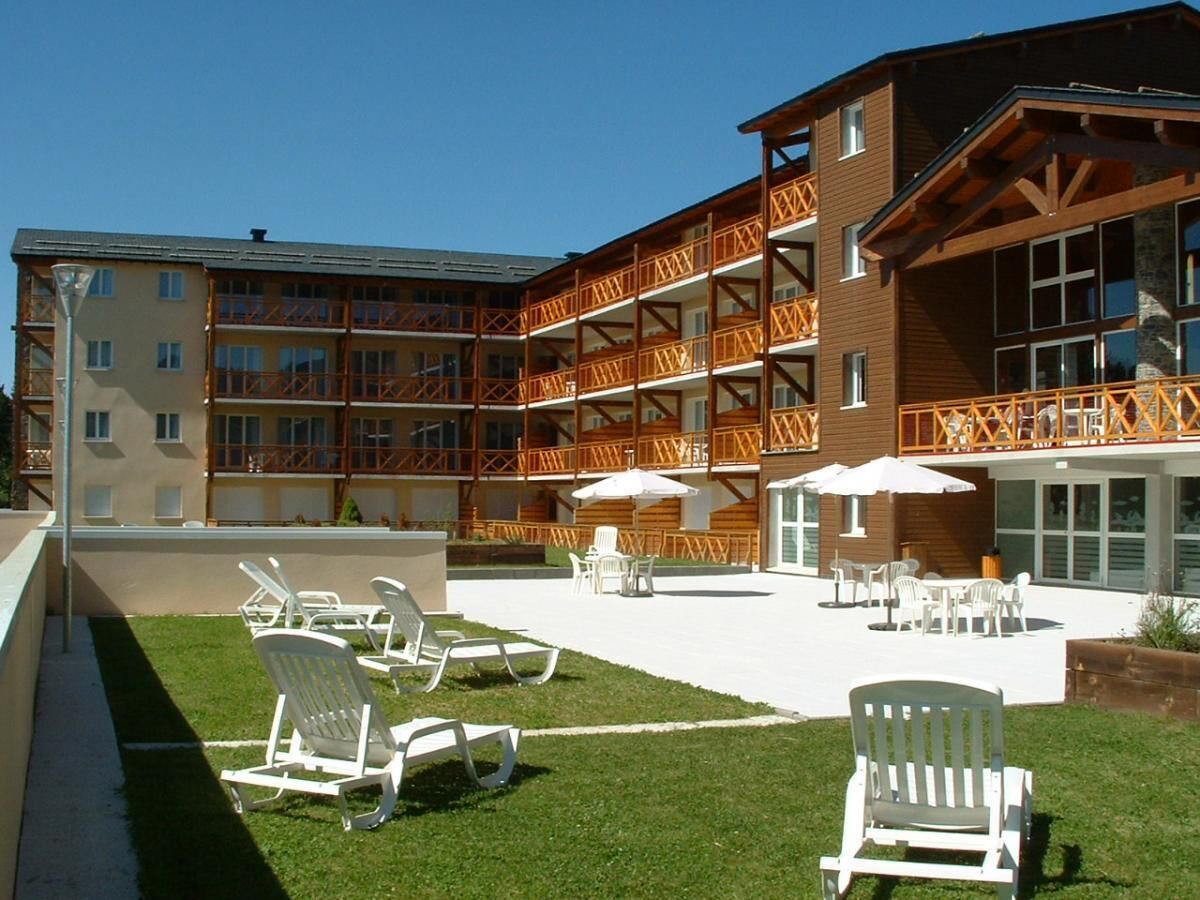 A hotel with outdoor seating and a pool area.