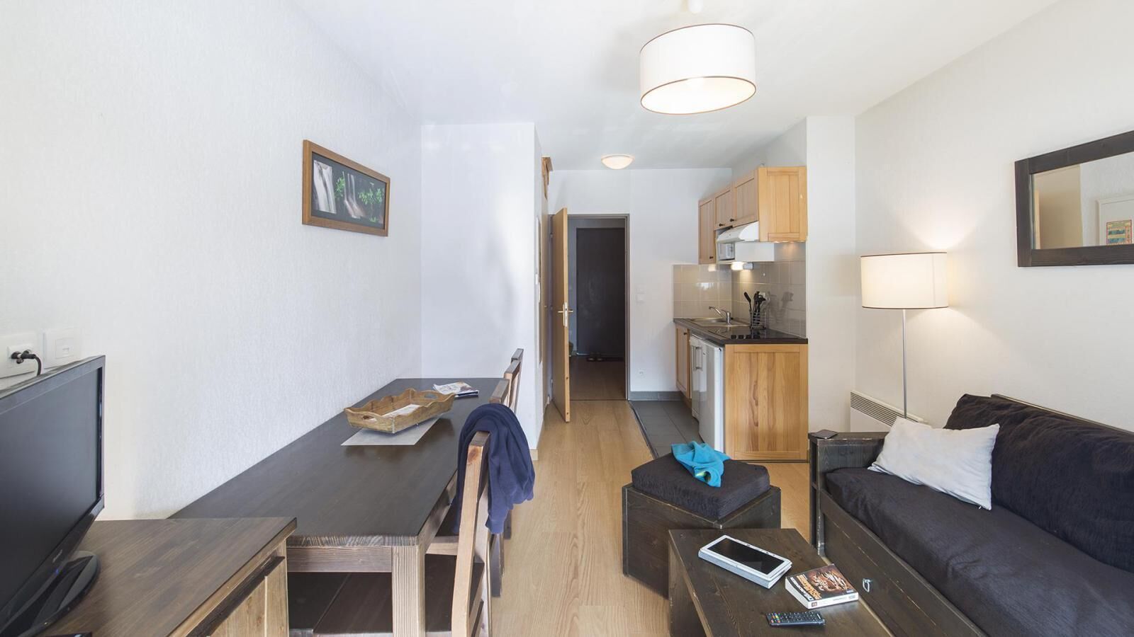 A compact living space with a dining area, kitchenette, and seating area.