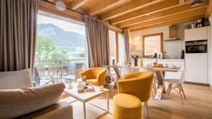 Un salon moderne avec un plafond en bois, un coin repas et une cuisine.