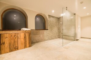 Ein modernes Badezimmer mit einem Holzbadezimmerschrank, einer Duschkabine aus Glas und gefliesten Wänden.