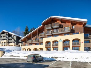 A multi-story hotel with balconies, a parking lot, and snow on the ground. - 50m from resort center, swimming pool, balcony, parking, tv, ski locker, 32m², Valmorel (La Léchère)