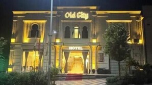 Un edificio con un letrero que dice "Old City HOTEL" y una escalera que conduce a la entrada.