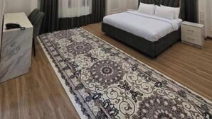 Een slaapkamer met een groot bed, een bureau en een kroonluchter.