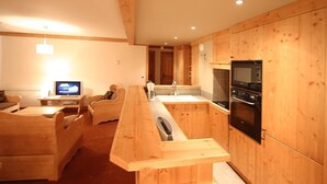 Une cuisine moderne avec des meubles en bois, un four encastré et un long comptoir-bar en bois.